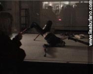Lisa Bufano contorted crab-like while wearing 28 inch wooden stilts, viewed through store front window